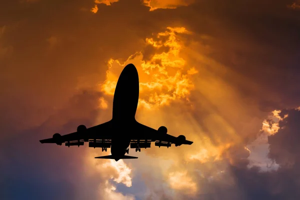 Siluetas avión vuelo despegue en el cielo al atardecer — Foto de Stock