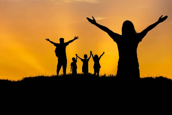 Silhouette Vater und Mutter und Kinder stehen erhobenen Händen auf dem Sonnenuntergang — Stockfoto