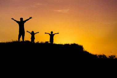 Siluet baba ve çocuk ayakta eller sunset bulvarında kaldırdı