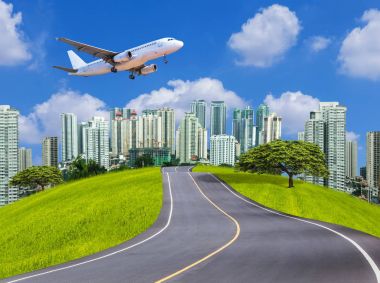 Boş asfalt yol üzerinde uçan uçak ile modern şehir için 
