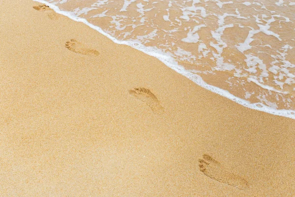 Pegadas em areia molhada na praia tropical — Fotografia de Stock
