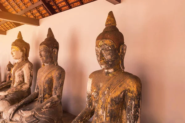 Estatuas de buda antiguas sentadas en fila en el templo tailandés público — Foto de Stock