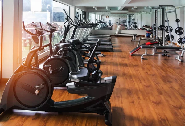 rows of stationary bikes and treadmills and equipment  health exercise for bodybuilding in modern fitness center