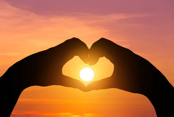 Silhouette två händer att göra formuläret hjärta form med solen solnedgång — Stockfoto