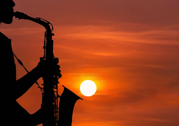 silhouette musician playing the saxophone in sunset