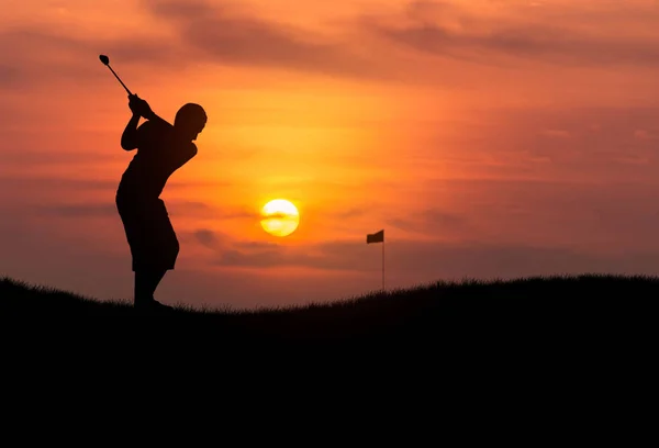 Silhouette jeune golfeur frappant balle de golf au coucher du soleil — Photo