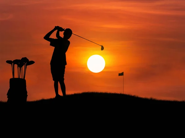 Silueta golfista zasáhnout golfový míček při západu slunce — Stock fotografie