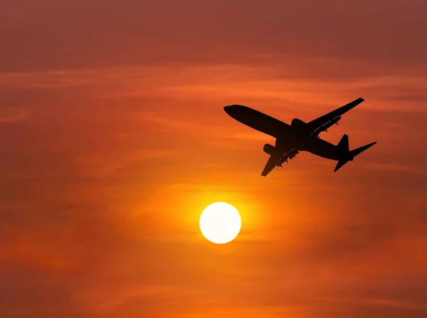 Silhouette airplane flying in to sky during sunset — Stock Photo, Image