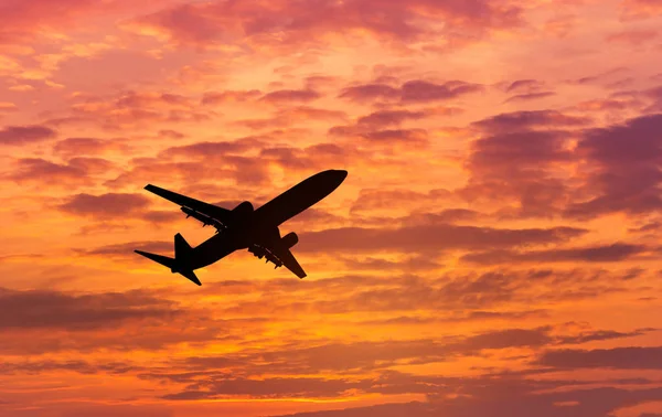 Avión de silueta volando hacia el cielo al atardecer — Foto de Stock