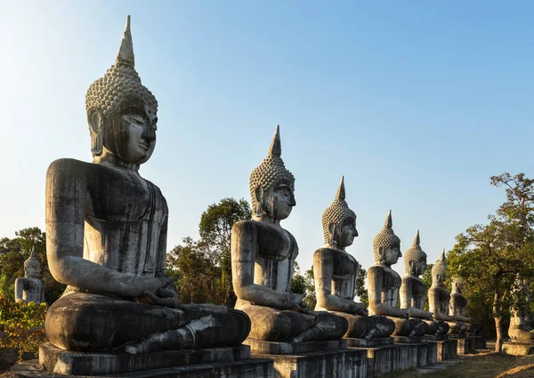 Silueta grandes estatuas de buda antiguas sentadas en fila en el templo tailandés público — Foto de Stock