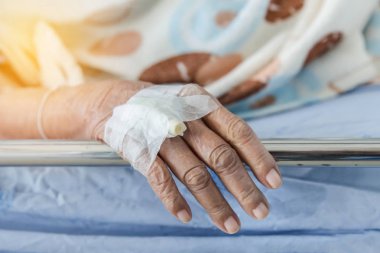 Yaşlı hasta enjeksiyon fiş intravenöz kateter ile el kadar elinde hastane koğuşunda odasında yalan sırasında kapatın