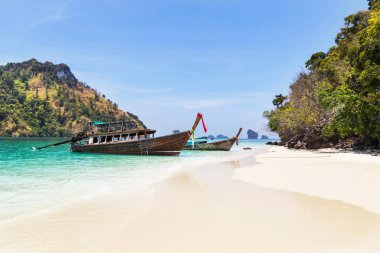 longtail tekneler, Krabi, Tayland andaman Denizi'nin mavi gökyüzü ile küçük kireçtaşı adalar arasında sahilde demirleme.