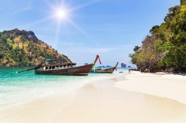 longtail tekneler, Krabi, Tayland andaman Denizi'nin mavi gökyüzü ile küçük kireçtaşı adalar arasında sahilde demirleme.