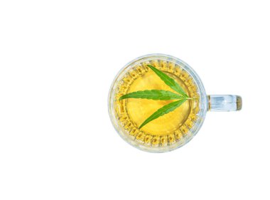 Marihuana bitkisel kenevir çayı ve yeşil kenevir yaprakları beyaz arka planda izole edilmiş bardak içinde.. 