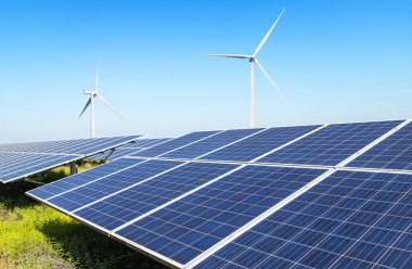 Güneş pilleri veya güneş panelleri veya rüzgar türbinli fotovoltaik hücreler mavi gökyüzü altındaki hibrit enerji santralinde alternatif yenilenebilir rüzgar enerjisi ve güneş ışığı enerjisi üretirler.