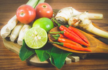 Tom Yum Çorbası veya River Karides Baharatlı Çorbası (Tom Yum Goong), ahşap arka planda, sağlıklı beslenme ve diyet gıda kavramında çeşitli sebzeler ve baharat karışımı.. 