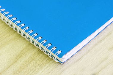 Boş mavi kitap boş kapak kitabı sarmal okul malzemeleri eğitim işi fikri kitabı kapak tasarım not defteri notları ahşap arka planda.
