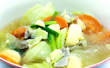 Beyaz tabakta domuz etli lahana çorbası..