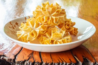 Thai tatlısı Çıtır Nilüfer Çiçeği Kurabiyesi veya Dok Şakası Ahşap masada