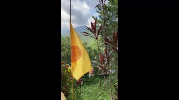 Buddhistische gelbe Flagge auf blauem Himmel und grünem Wald — Stockvideo