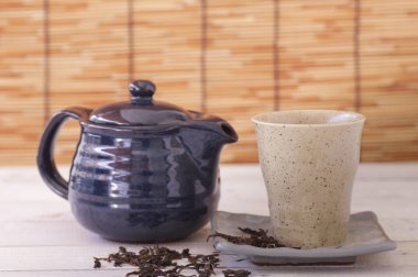 ahşap masa üzerinde seramik demlik çay