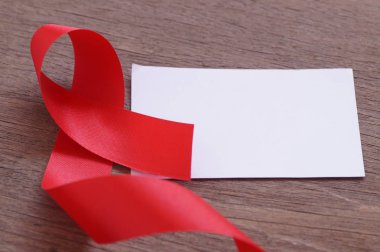 AIDS, kırmızı kurdele ve Word'ün yardım ve korumak, ahşap arka plan üzerinde beyaz kağıt