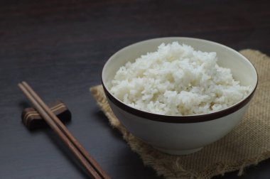 Ahşap arka plan üzerinde yemek çubukları ile Tayland pirinç