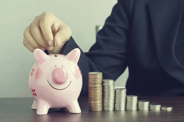 Hand of businesswoman put money on pink of piggy — Stock Photo, Image