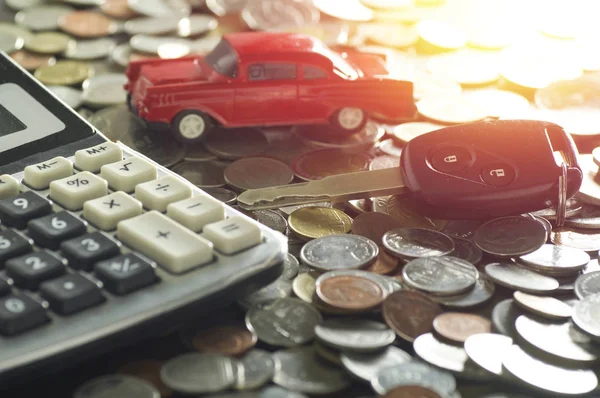 Autoschlüssel auf Geldmünzen und Taschenrechner auf dem Tisch — Stockfoto