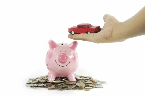 Auto in der Hand mit rosa Sparschwein auf Münzen isoliert — Stockfoto