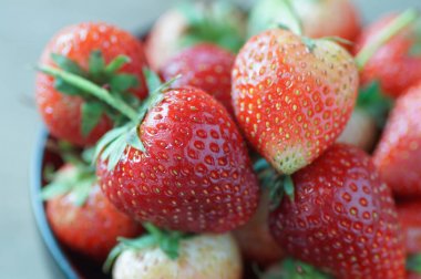 Tahta masadaki kasede taze çilekler.