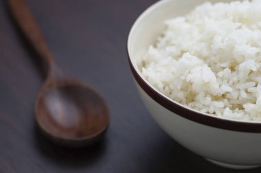 Ahşap arka plan üzerinde yemek çubukları ile Tayland pirinç