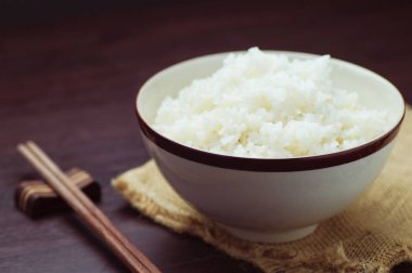 Ahşap arka plan üzerinde yemek çubukları ile Tayland pirinç