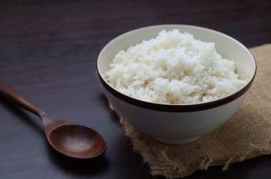 Koyu tonda masada tahta kaşıkla kapta Tayland pirinç