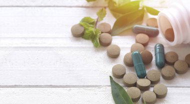 ahşap masa ve kopya alanı üzerinde yukarıdan bitkisel hap