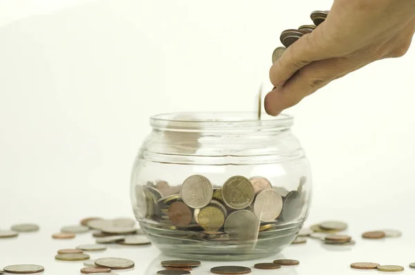 Hand put coin  at  bottle of  money on blue background, concept in growth, save and investment in business — Stock Photo, Image