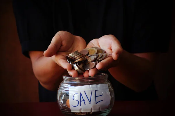 man holing coins and put money on glass and jar to save and donate