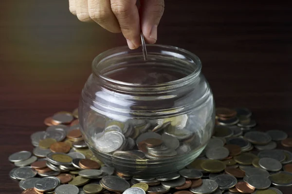 Hand put money on glass and jar, concept in save and growth — Stock Photo, Image