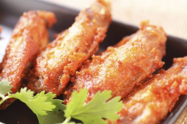 Baharatlı derin kızarmış tava tavuk kanadı Ranch ve kişniş siyah plaka üzerinde kapatın