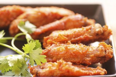 Baharatlı derin kızarmış tava tavuk kanadı Ranch ve kişniş siyah plaka üzerinde kapatın