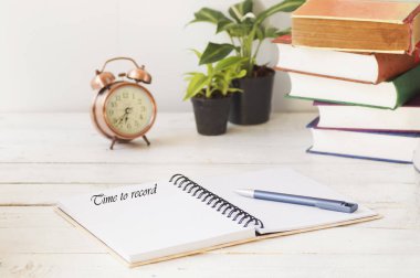 üstünde defter kalem ve ahşap masa saati ile boşaltmak