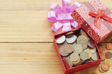 Açık hediye kutusu sikkeleri üzerinde tahta arka plan ile