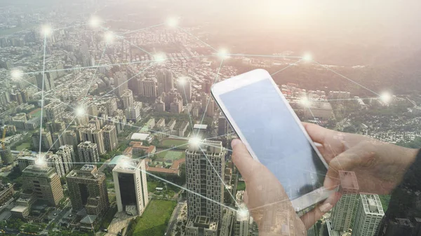 Double exposure of hand touch screen on Smartphone and city, concept in connection