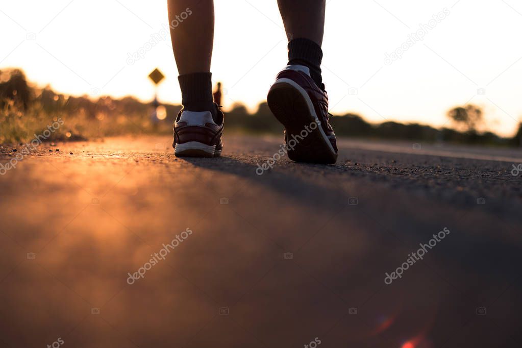 Solhouette of foot running on road in healthy and winne