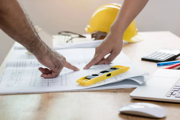 Engenheiro ou arquiteto olhando e apontando no papel plano na mesa — Fotografia de Stock