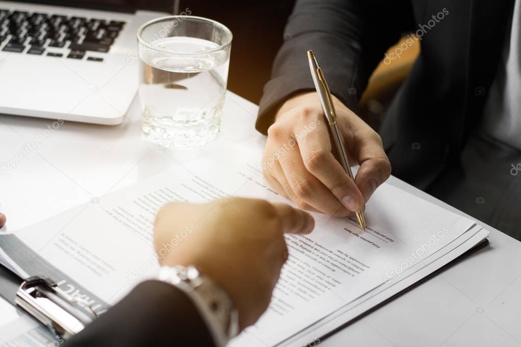 Businessman signing contract paper with partner, reach agreement