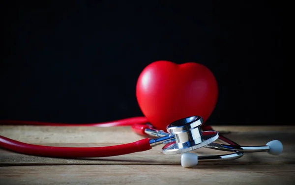 Steth y forma roja del corazón en la mesa de madera, concepto de coche sano — Foto de Stock