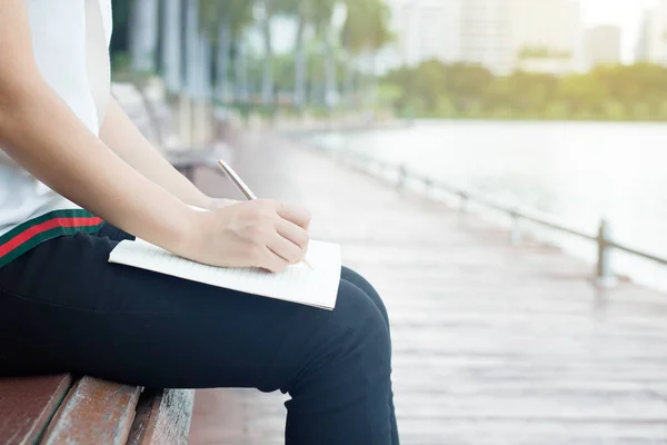 Vrouwen zitten en schrijven op de notebook in park — Stockfoto