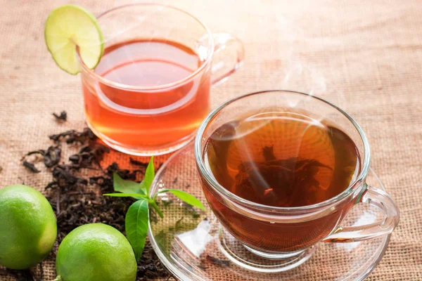 Чашка чая с ломтиком лимона на деревянном столе — стоковое фото