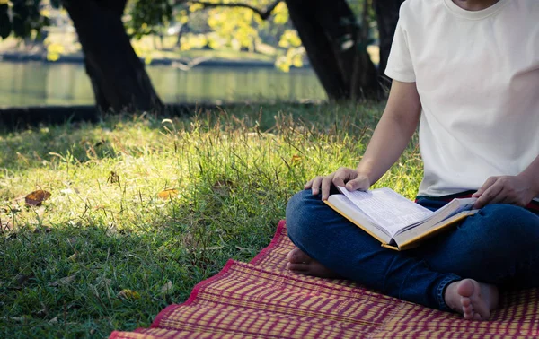 Jonge vrouwen lezen boek in park, concept in kennis en educa — Stockfoto